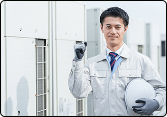 ヘルメットを持つ作業服姿の男性